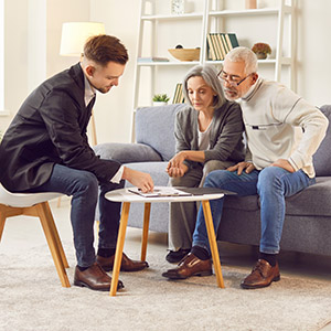 Senior couple consulting a lawyer; reviewing legal documents for estate or asset planning.