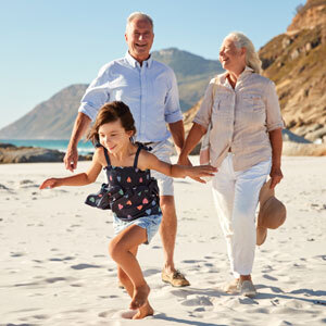 Grandparents walking with a child on the beach – understanding guardianship laws for loved ones. - Hyl Conte Law, PLLC